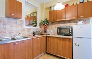 Apartamento | Cozinha privada | Geladeira, talheres/pratos/utensílios de cozinha