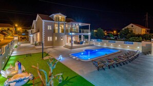 A modern two-story house with a swimming pool and outdoor seating. - Nice Home in Dubrava kod Sibenika With Outdoor Swimming Pool, Wifi and 5 Bedrooms (Sibenik)