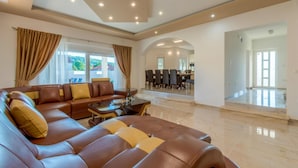 A spacious living room with a leather sofa, a dining area, and a view of the outdoors. - Nice Home in Dubrava kod Sibenika With Outdoor Swimming Pool, Wifi and 5 Bedrooms (Sibenik)