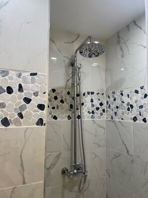 Bañera con ducha, secador de pelo, toallas, papel higiénico