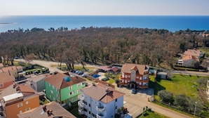 Zona residencial com casas, uma rua e vista para o mar.