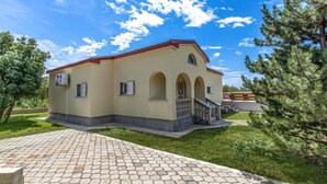 A two-story building with a red roof, arched windows, and a small balcony. - Stunning Home in Smrika With Wifi and 3 Bedrooms (Kraljevica)
