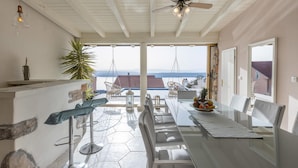 A spacious patio with a dining table, chairs, and a hanging chair overlooking a scenic view. - Amazing Home in Dramalj With Wifi, 2 Bedrooms and Outdoor Swimming Pool (Crikvenica)