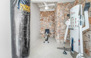 A home gym with a punching bag, exercise equipment, and a cable machine. - Amazing Home in Dramalj With Wifi, 2 Bedrooms and Outdoor Swimming Pool (Crikvenica)