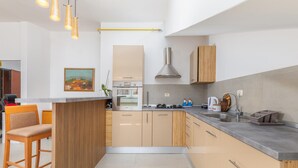 A modern kitchen with a central island, wooden cabinets, and a stainless steel sink. - Stunning Apartment in Pula With Wifi and 2 Bedrooms (Pula)