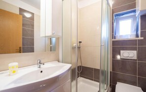 A bathroom with a glass-enclosed shower, a sink with a mirror, and a toilet. - Beautiful Home in Split With Wifi and 4 Bedrooms (Split)