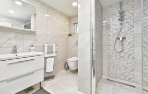 A modern bathroom with a glass-enclosed shower, a white vanity with a mirror, and a toilet.