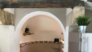 A kitchen with a white archway leading to a curved counter, a coffee machine, and a potted plant. - Isis, small house, South Vendée, Puy du fou, Marais Poitevin (CEZAIS)