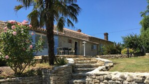 A stone house with a tiled roof, a palm tree, and a rose bush. - Isis, small house, South Vendée, Puy du fou, Marais Poitevin (CEZAIS)