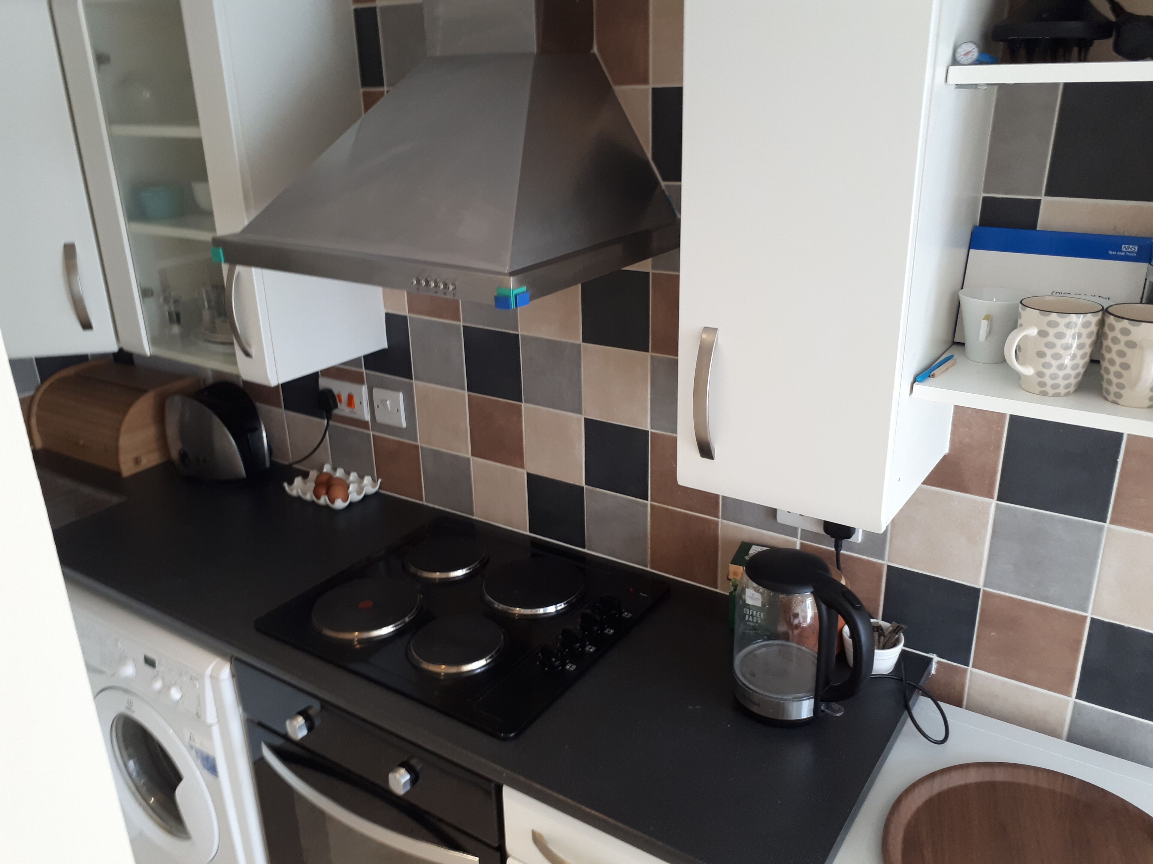 Une cuisine équipée d’une cuisinière, d’une machine à café et d’un four à micro-ondes.