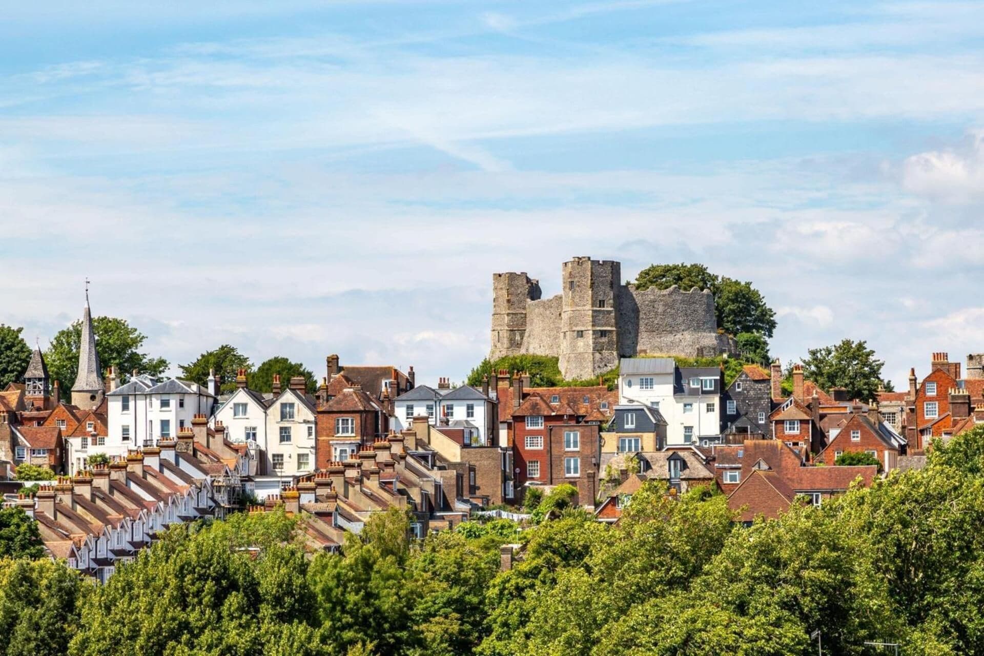 Eine historische Stadt mit traditionellen Häusern und einer markanten Burg auf einem Hügel.