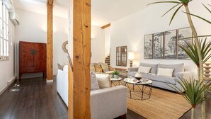 A living room with a sofa, coffee table, and a painting on the wall.