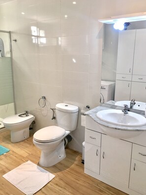Une salle de bain moderne équipée de toilettes, d’un bidet et d’un lavabo.