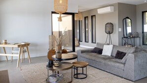A modern living room with a grey sofa, round coffee table, and hanging wicker lamps. - VILLA BELLA - 4 bedrooms, heated swimming pool, panoramic sea view (Grosseto-Prugna)