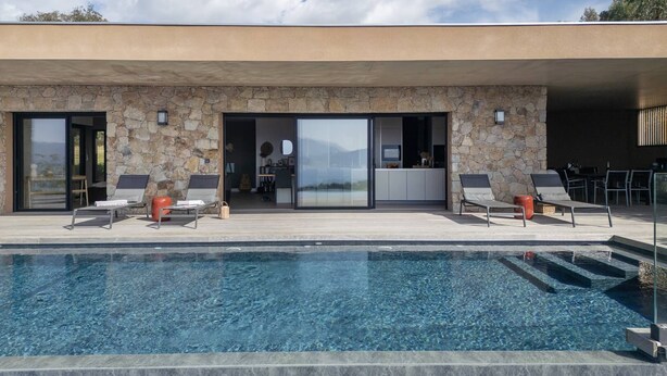 A modern house with a swimming pool, stone exterior, and a view of the landscape. - VILLA BELLA - 4 bedrooms, heated swimming pool, panoramic sea view (Grosseto-Prugna)