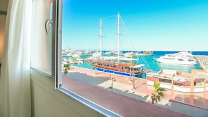 Un port de plaisance avec des bateaux, un quai et un bâtiment orné d’enseignes.