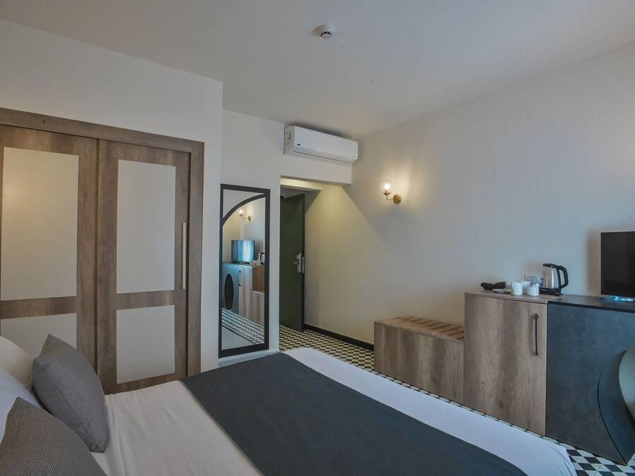 Une chambre d’hôtel équipée d’un lit, d’un bureau, d’un miroir et d’une kitchenette.