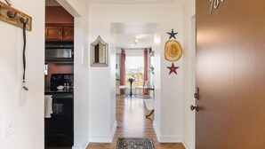 A hallway leading to a dining area with a view of the city, a wooden floor, and a door labeled "180". - Downtown Condo with River View (Nashville)
