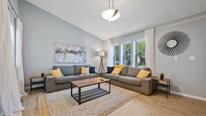 A modern living room with two sofas, a coffee table, and a floor lamp. - Adorable 3 bed, 1.5 bath Ranch Home with fenced yard (Columbus)
