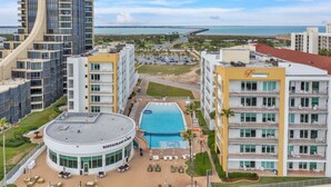 Un hotel con piscina, mobiliario exterior y vistas a la playa y al océano.