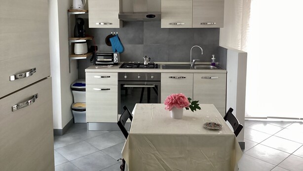 A modern kitchen with a dining table, a coffee maker, a toaster, and a sink. - Peter's nest (Verano Brianza)