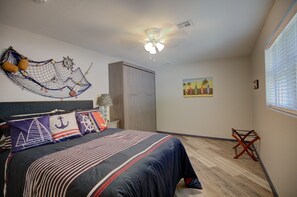 A bedroom with a bed, a ceiling fan, a wall-mounted hammock, and a painting. - Waterfront Home with private boat ramp and boat dock. (Grove)