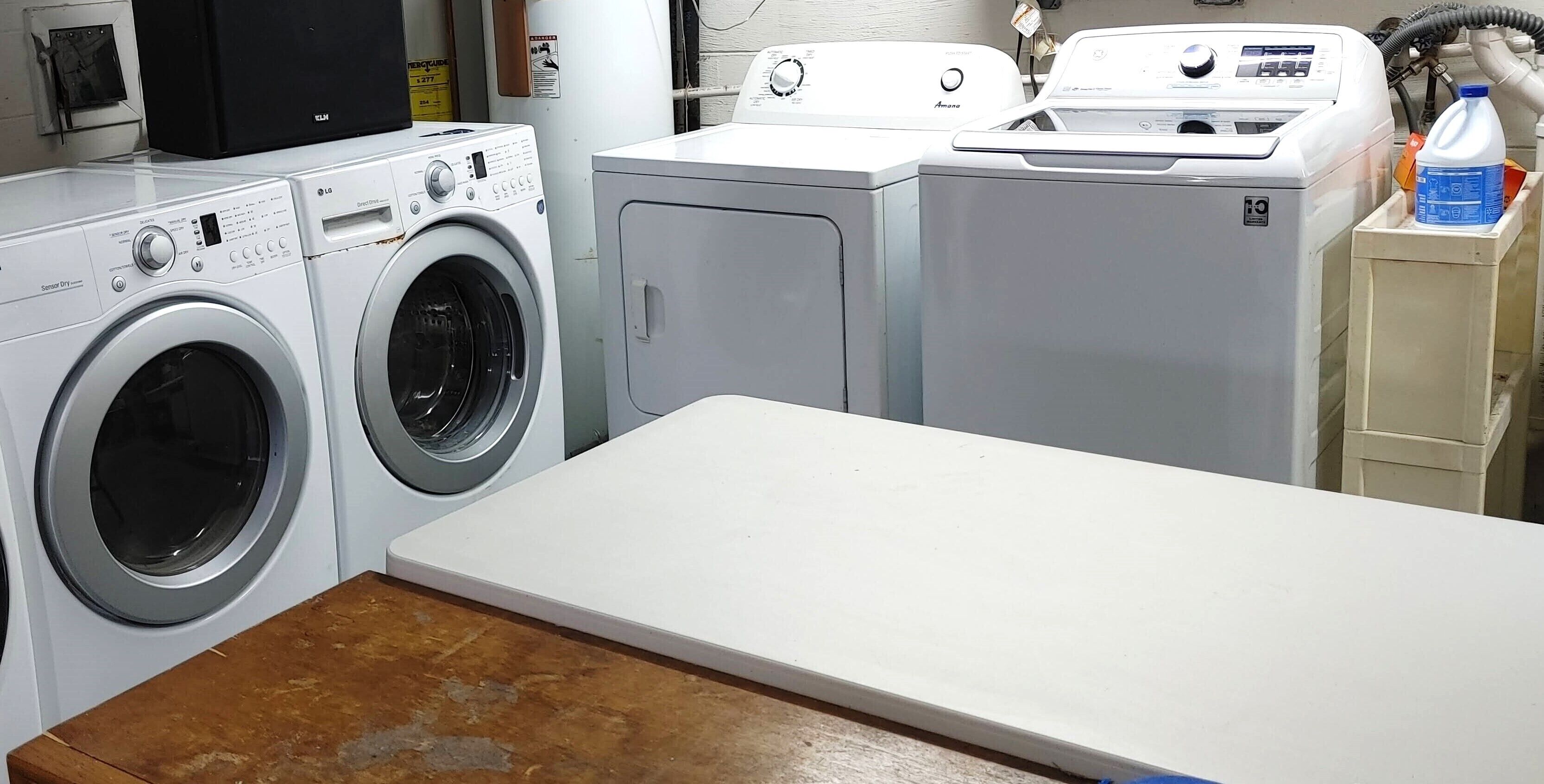 Un espace buanderie comprenant un lave-linge, un sèche-linge et une table.
