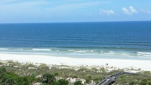 A beach with a wooden boardwalk leading to the shore, sandy beach, and ocean. - RV NSB Sun & Shade Tree, Pool & Picnic RV Vacation (New Smyrna Beach)