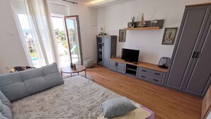 A modern bedroom with a large bed, a TV, and a wardrobe.