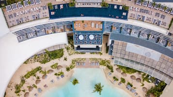 Luchtbeeld van een resort met een centraal zwembad, verschillende loungegebieden en een fontein.