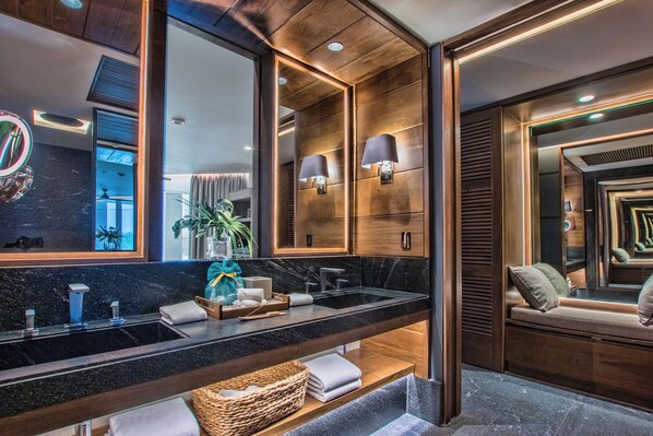 Une salle de bain moderne dotée d’un grand miroir, de deux vasques et d’un espace coiffeuse.