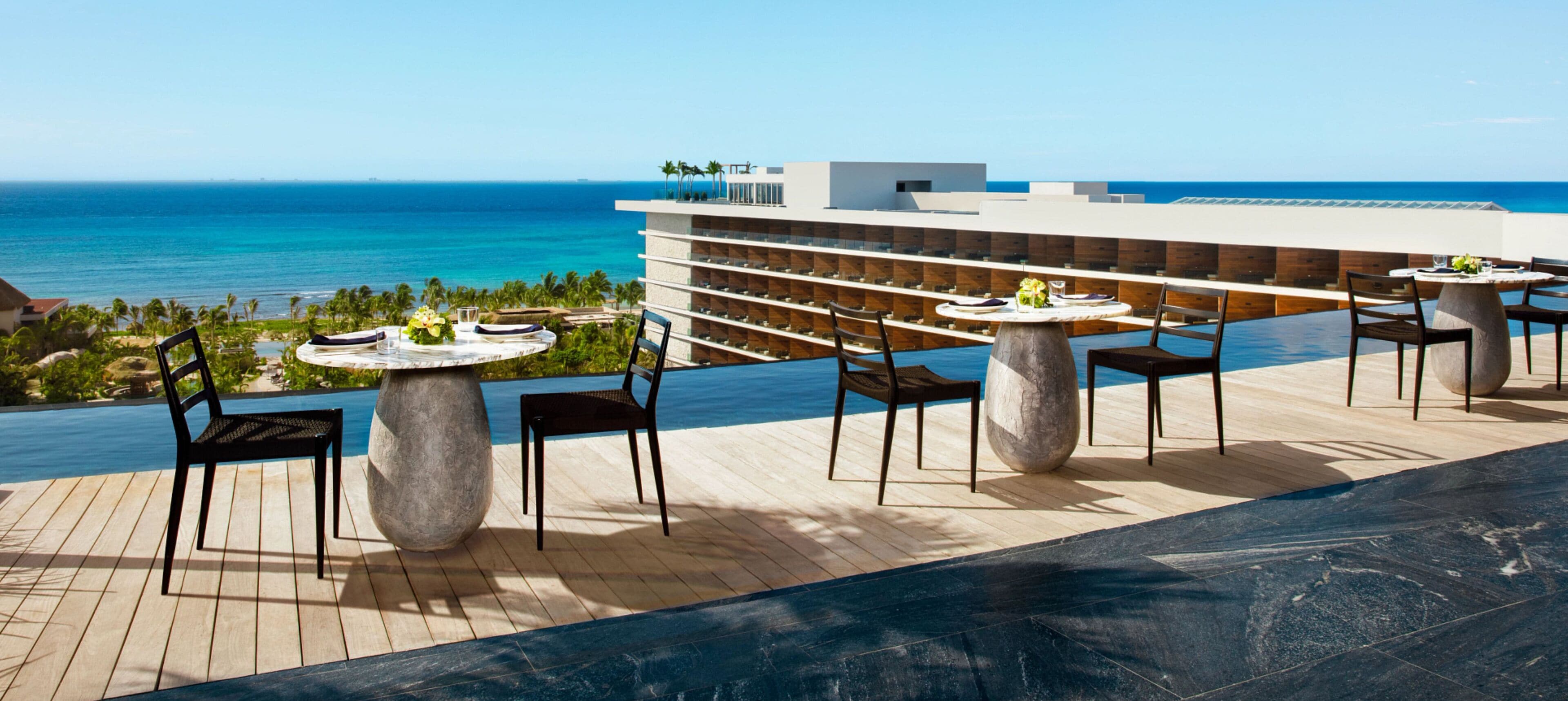 A rooftop terrace with outdoor seating and a view of the ocean.