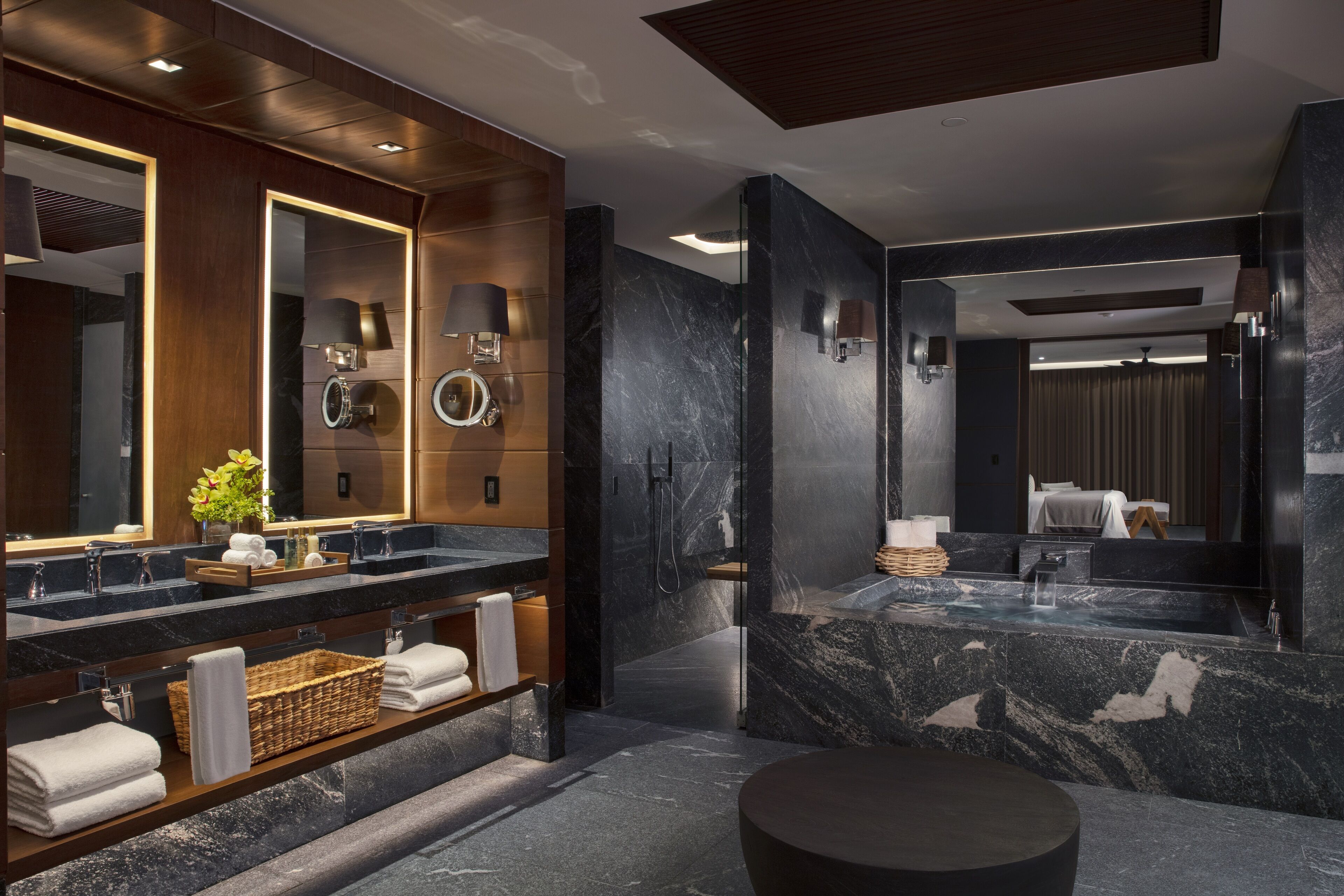 A modern bathroom with dual sinks, marble countertops, and a large mirror.