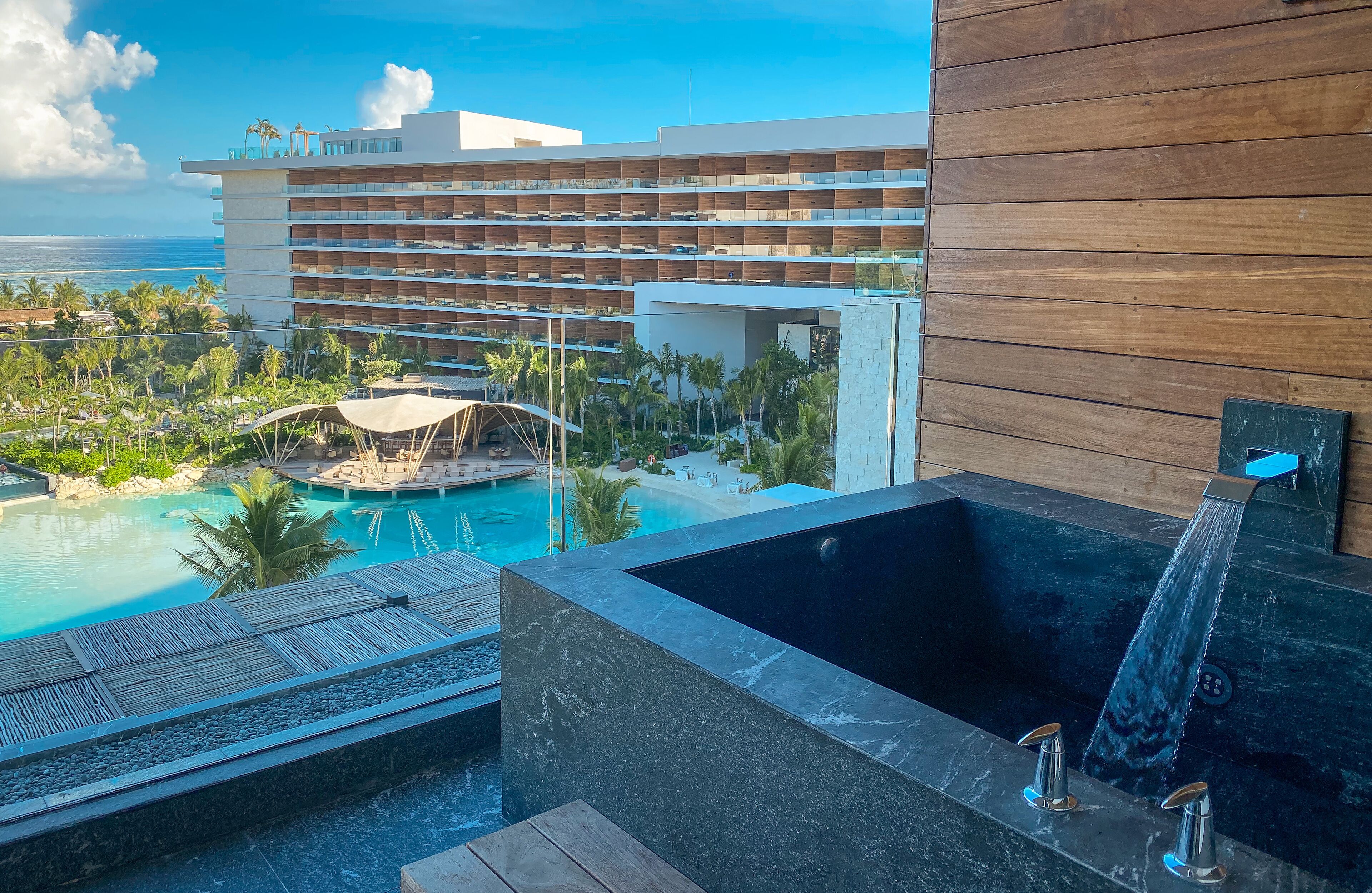 Ein Hotel mit Pool, Whirlpool und Blick auf den Ozean.