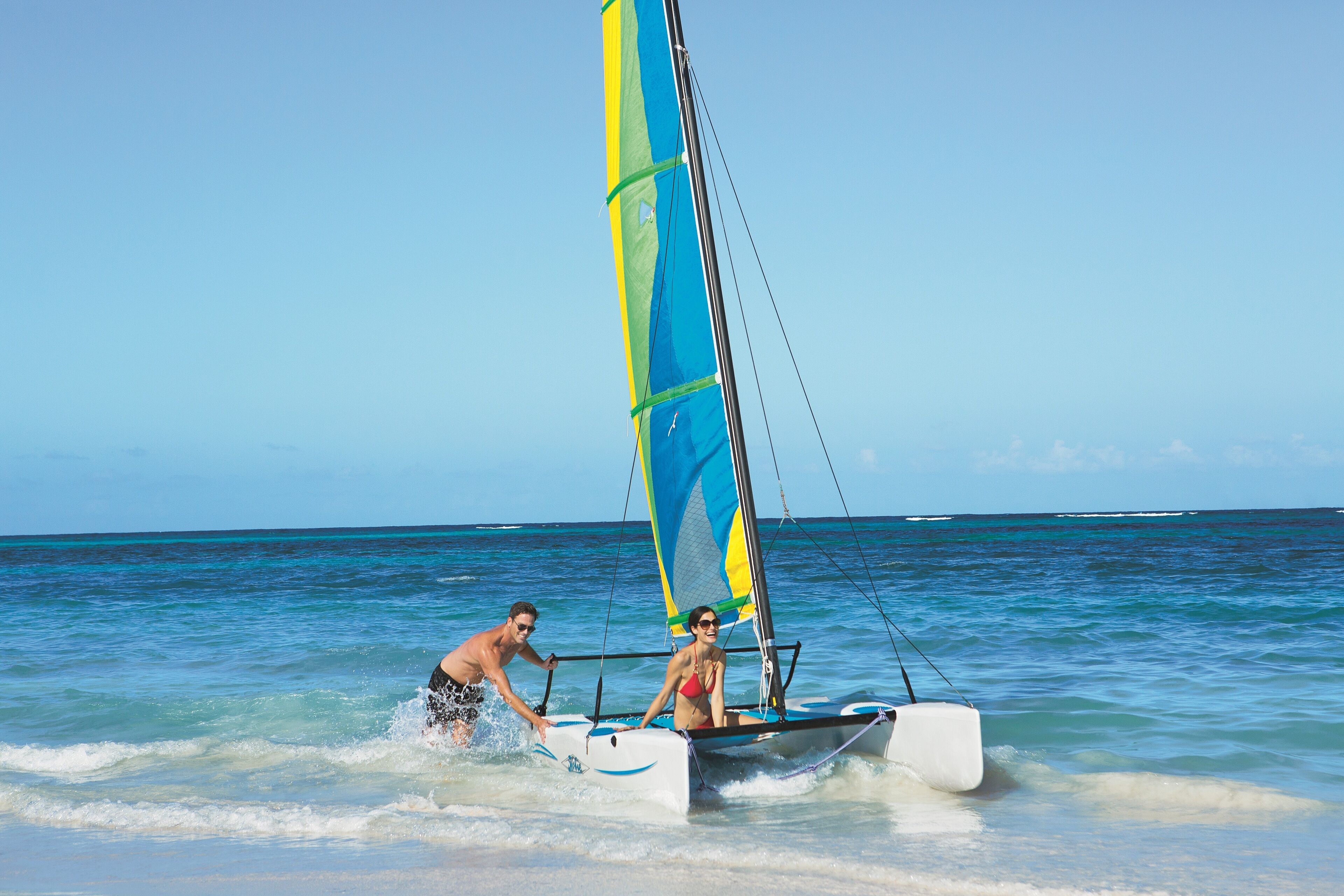 Una pareja navegando en un velero en el océano.