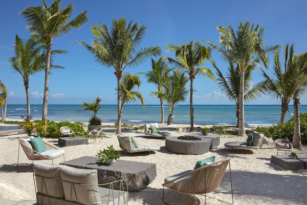 On the beach, white sand, beach cabanas, sun loungers