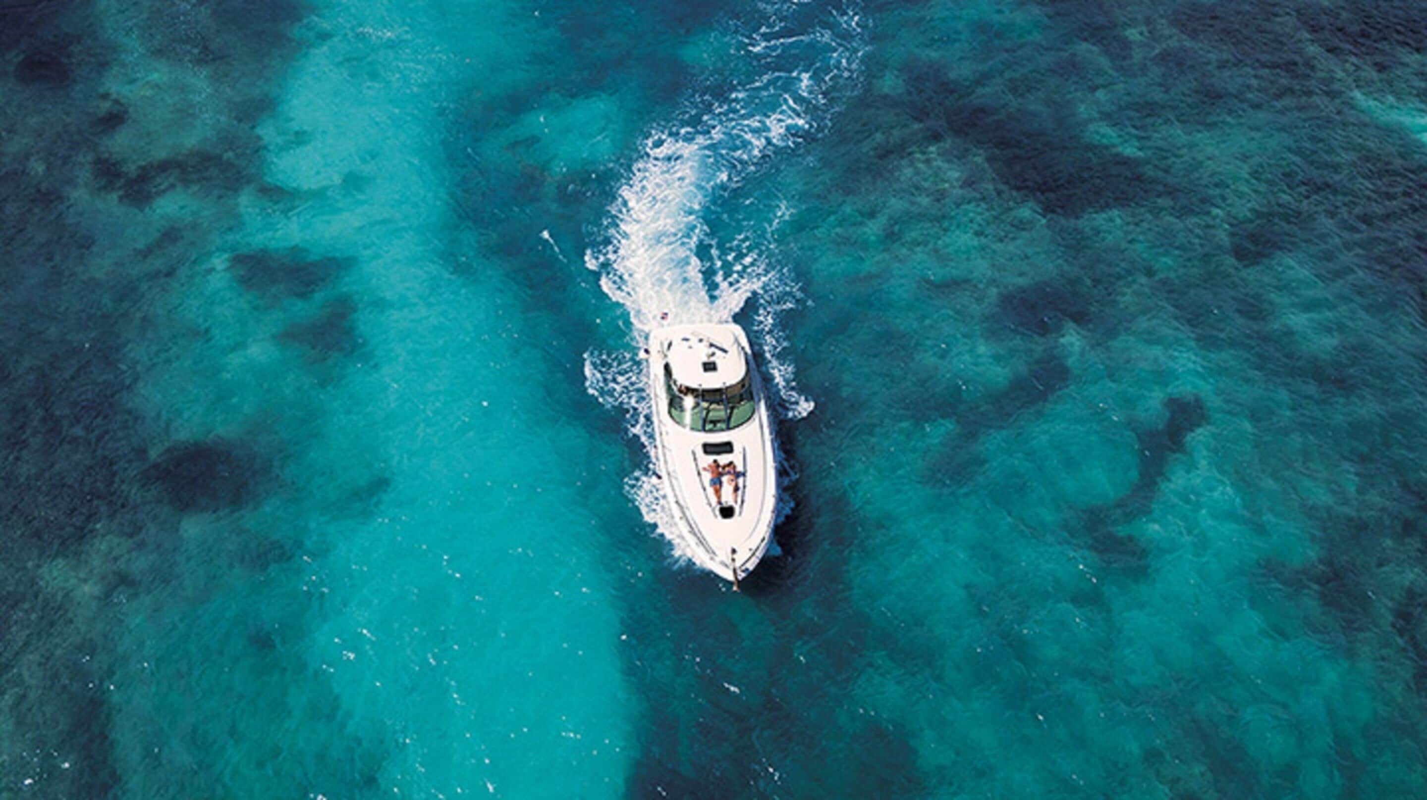 A white boat on clear turquoise water.