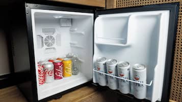 A refrigerator with a shelf containing various beverages and a door with a beverage dispenser.