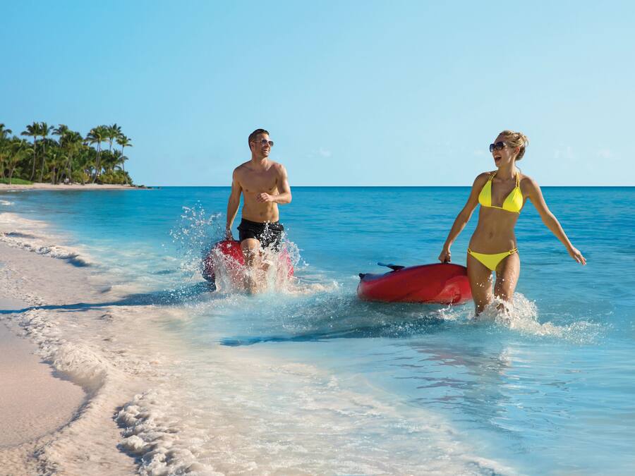 A beach with clear blue water and a sandy shore.