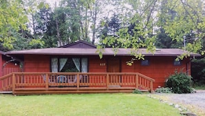 A single-story cabin with a porch and a number 227 sign. - Julieann's in Alaska - Home in the Heart of Sitka (Sitka)