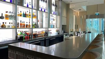 Eine moderne Bar mit einer langen Theke und Regalen voller verschiedener Flaschen.