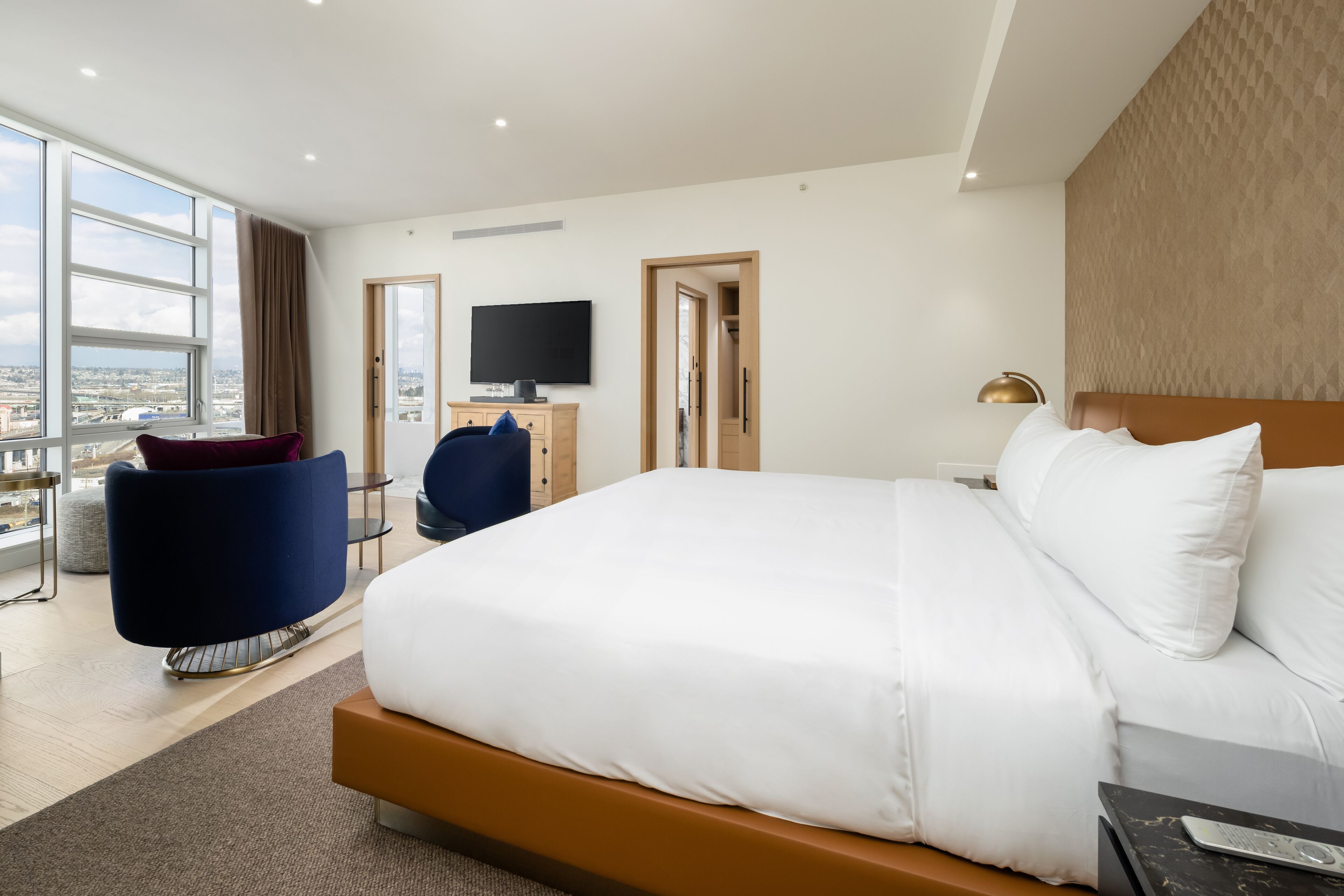 Une chambre d’hôtel moderne équipée d’un grand lit, d’une télévision, d’un bureau et d’une chaise.