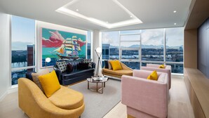 A modern living room with large windows, a city view, and contemporary furniture.