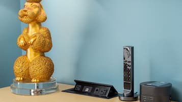 Un bureau agrémenté d’une statue dorée, d’une station de recharge et d’un haut-parleur.