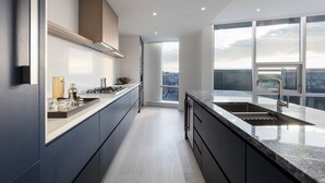 A modern kitchen with a large window, a built-in stove, and a sink.