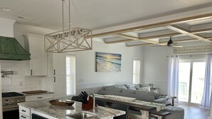 Una cocina moderna con armarios blancos, encimera de mármol y horno empotrado.