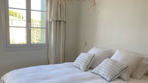 A bedroom with a large bed, white bedding, and a hanging light fixture. - Superb house on the ROOF, Terrace with SUPERB VIEW on the CANALS and JACCUZZI (Grimaud)