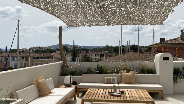 A rooftop terrace with outdoor seating, including sofas and wooden tables, under a pergola. - Superb house on the ROOF, Terrace with SUPERB VIEW on the CANALS and JACCUZZI (Grimaud)