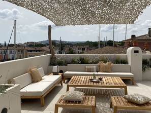A rooftop terrace with outdoor seating, a pergola, and a view of the cityscape. - Superb house on the ROOF, Terrace with SUPERB VIEW on the CANALS and JACCUZZI (Grimaud)