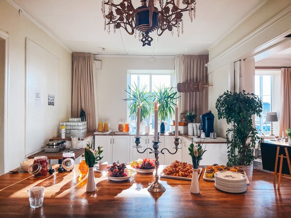 Zona de dinar amb taula de fusta, espelmes i diferents aliments.
